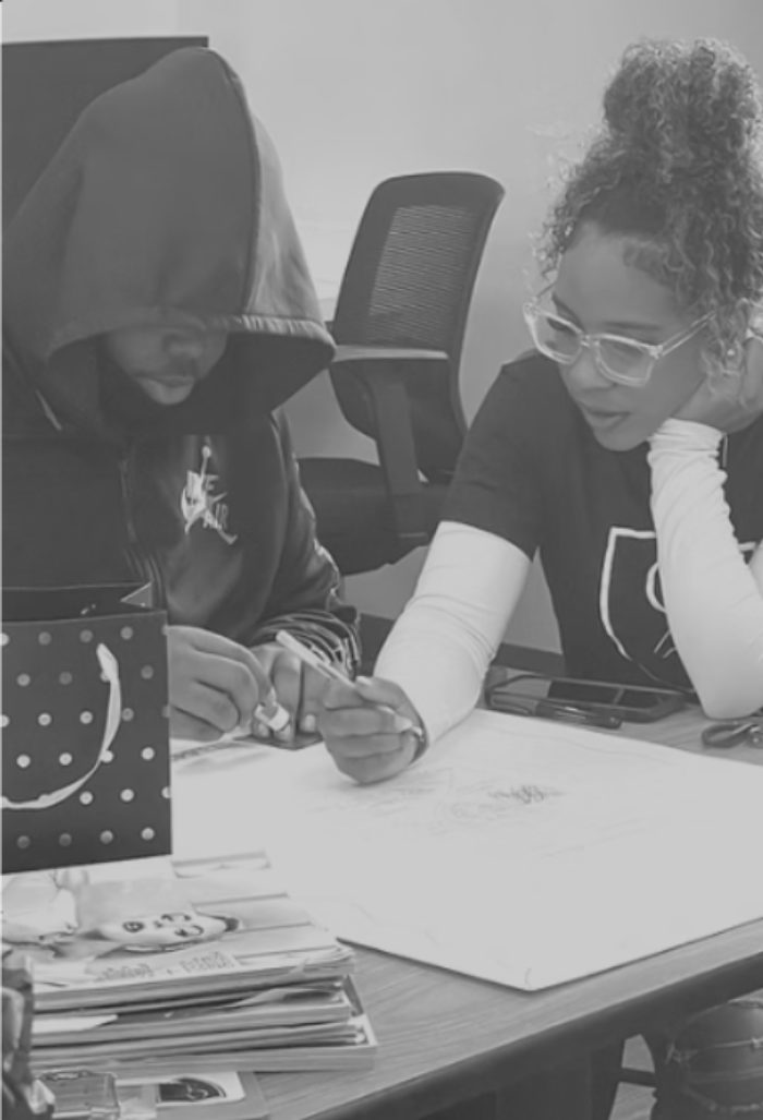 Two CBA students collaborating on a design sketch