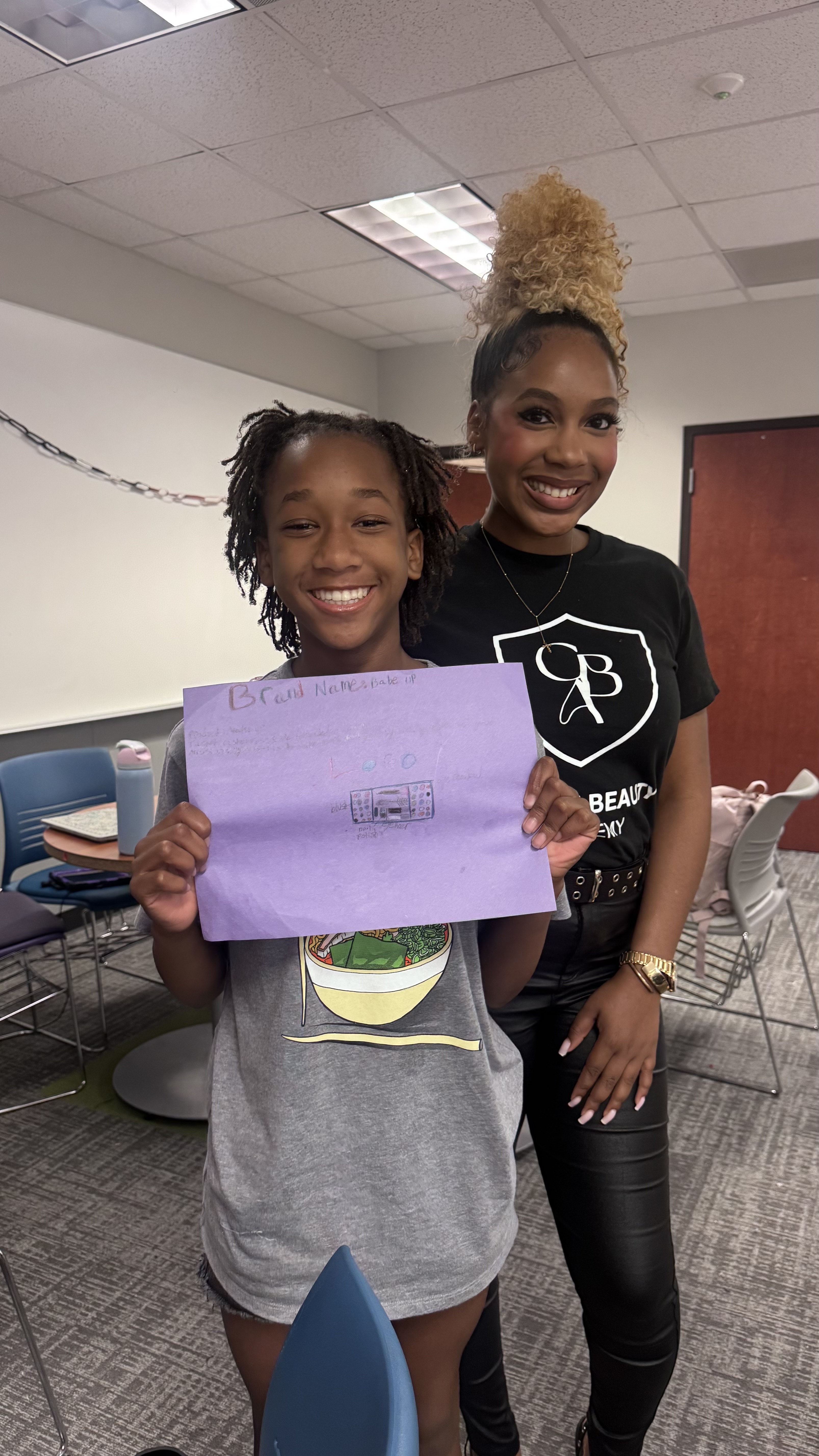 CBA student proudly presenting her brand concept alongside her instructor